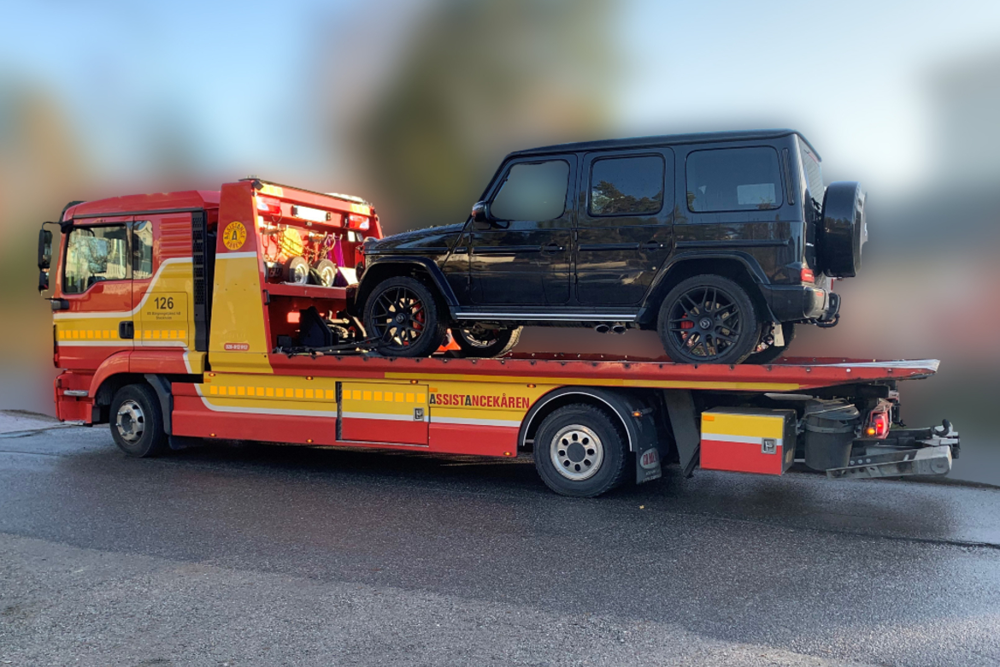 En svart bil är på en bärgningsbil.