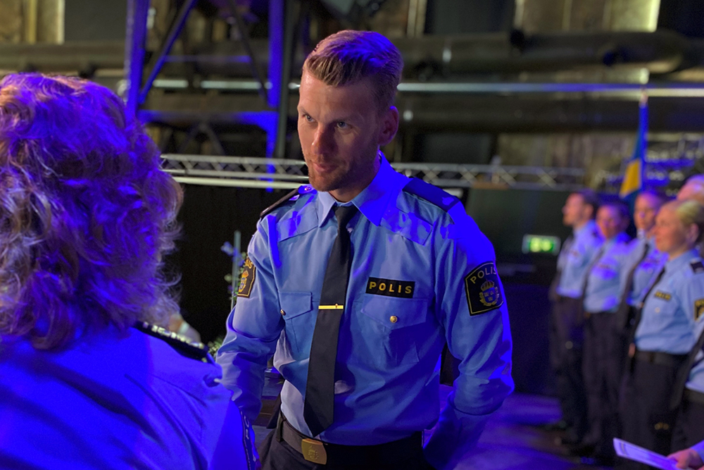 Ett fotografi som visar när en av poliserna får sitt utbildningsbevis under avslutningsceremonin.