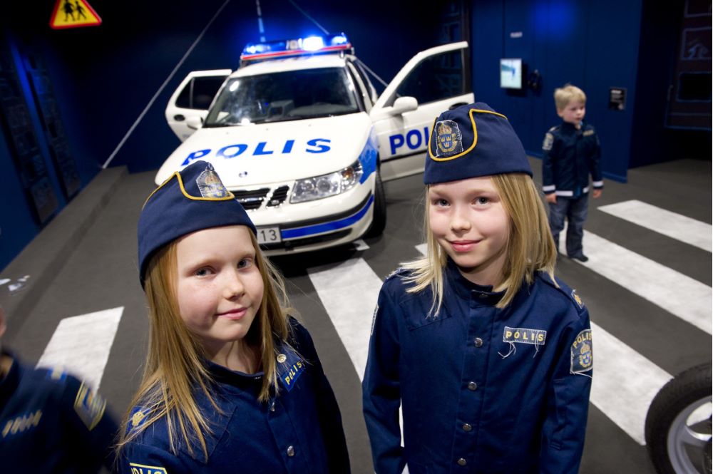Barn i polisuniform vid polisbil