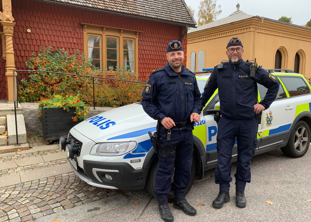 Två manliga poliser i uniform framför tingshuset i Kopparberg