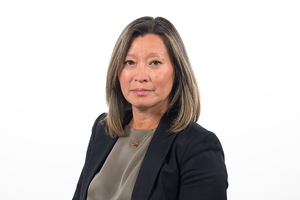 Kvinna i kavaj mot vit bakgrund