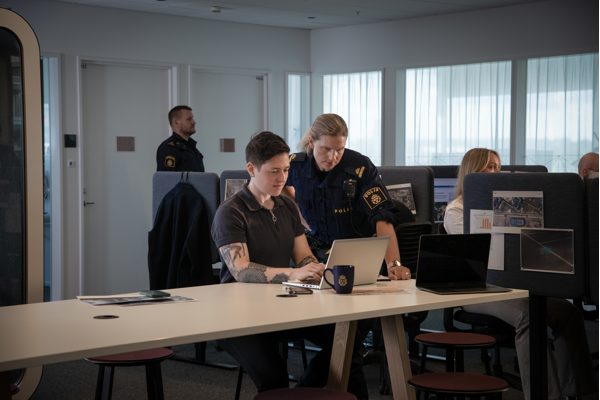 Kampanjbild, polis och medarbetare på it framför dator