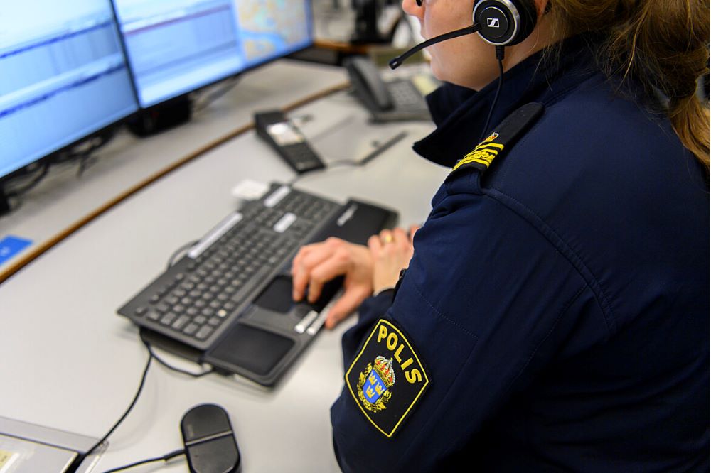 Polis med ryggen mot kameran som knappar på ett tangentbord