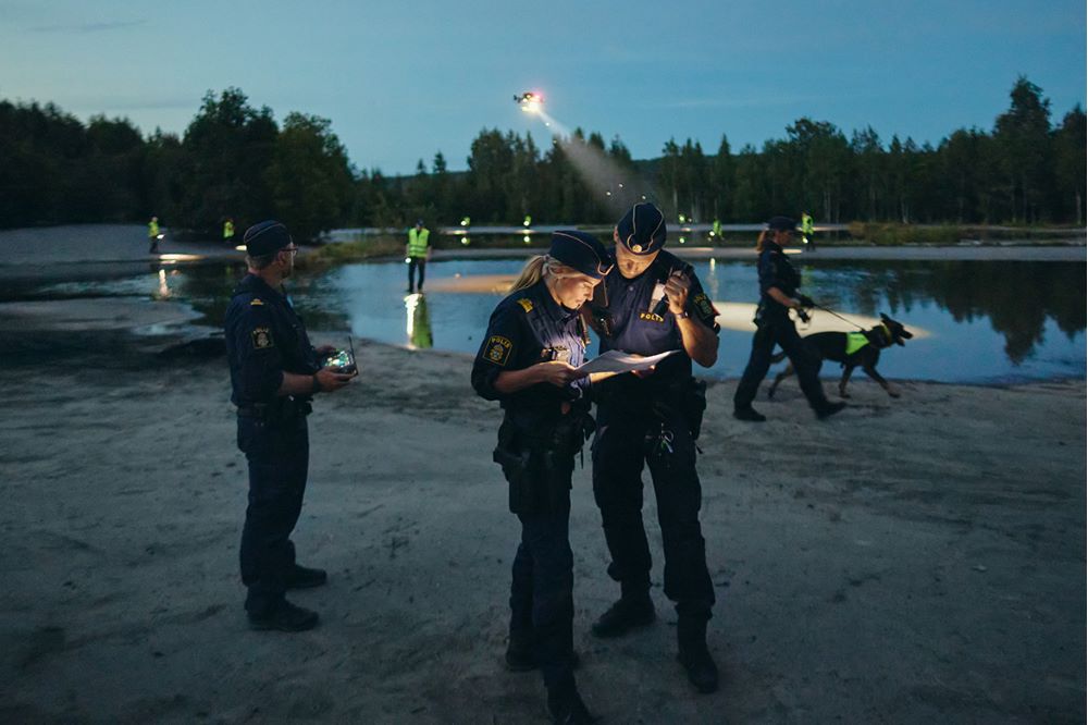 Poliser som jobbar vid en sjö i mörkret