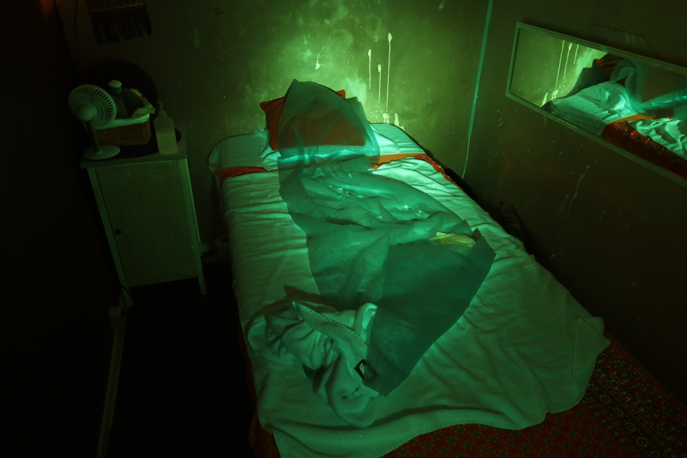 Bild från kriminalteknikers brottsplatsundersökning på massagesalongen med  fluorescerande belysning som indikation på sperma.