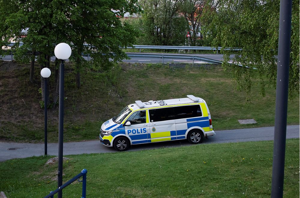 En målad polisbuss kör igenom ett bostadsområde.