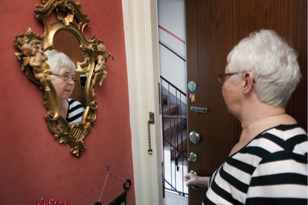 Elderly woman opening a door