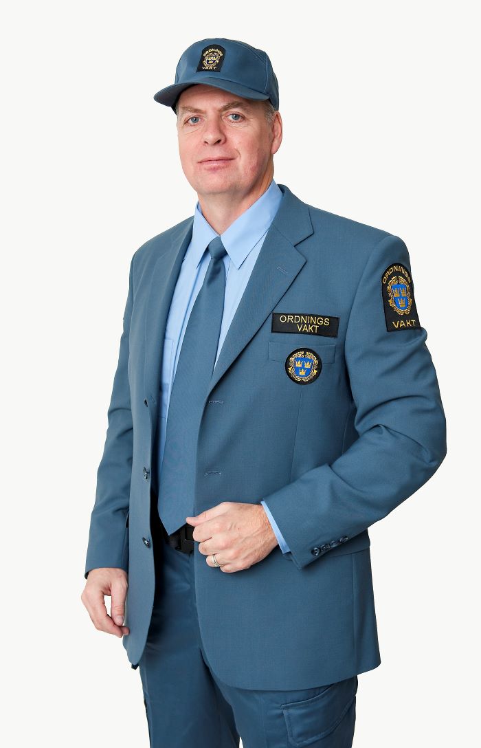 Ordningsvakt i kostym med slips och keps.
