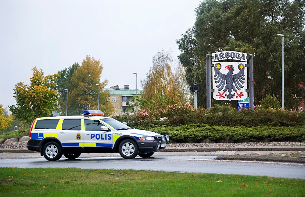 Polisbil synlig körandes i en rondell med skylt i bakgrunden med texten Arboga