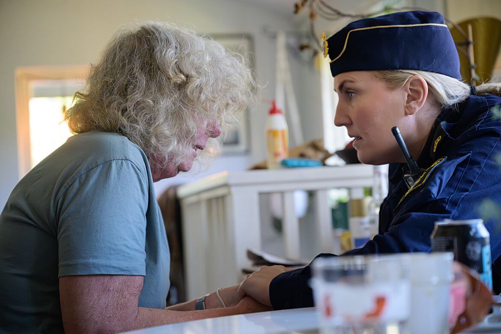 En kvinnlig polis talar med en äldre kvinna.