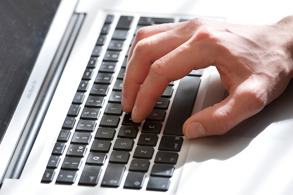 Hand skriver på tangentbord.