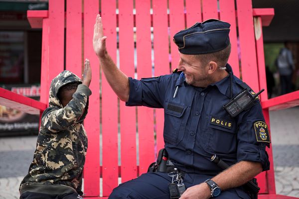 Ett barn och en polis gör high five.