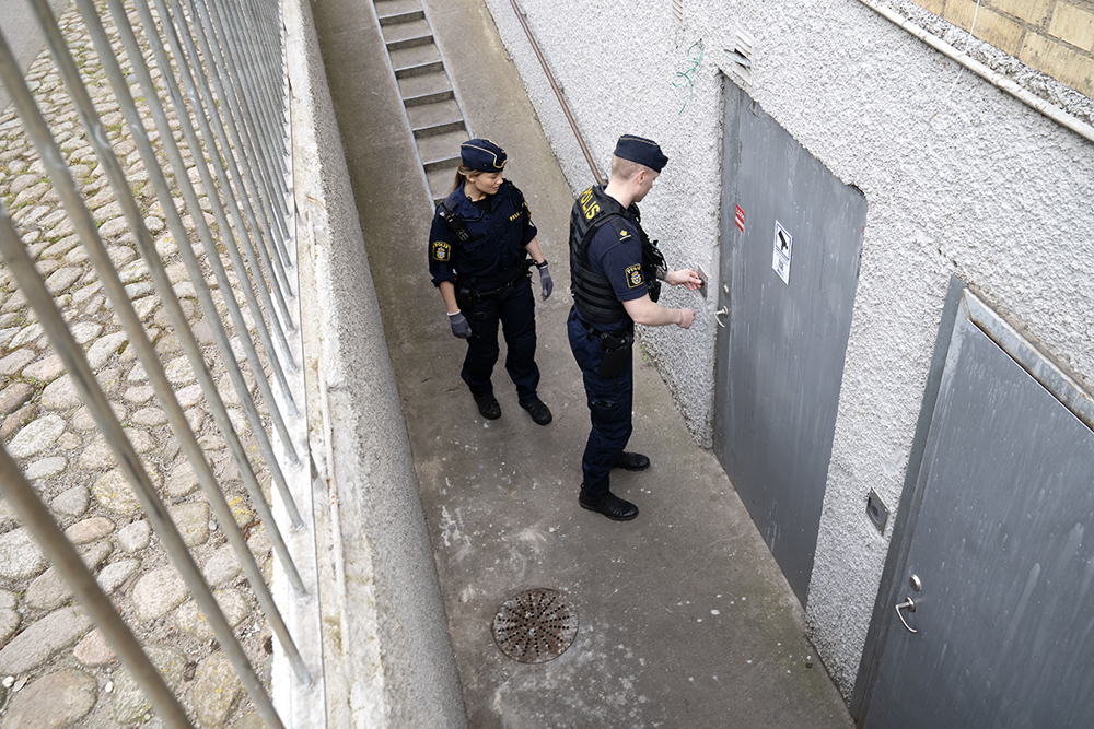Två poliser låser upp en källardörr