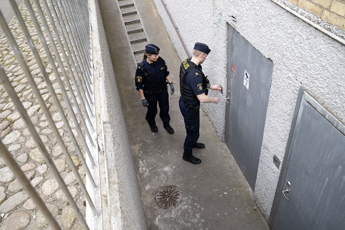 Två poliser låser upp en källardörr