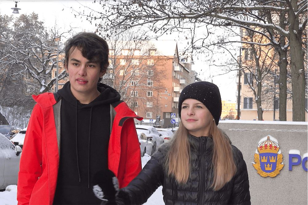 Två vinterklädda personer står utomhus och håller i en intervju.