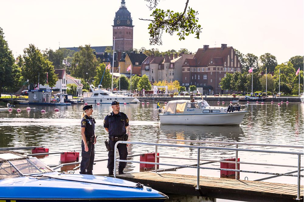 Två poliser i Strängnäs hamn. Domkyrkan syns i bakgrunden.