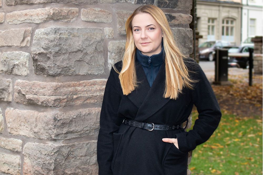 Linn står utomhus vid en mur