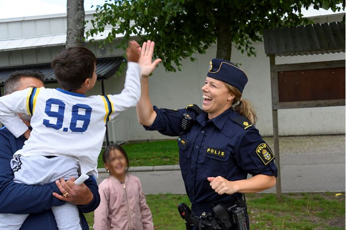 En polis och ett barn gör en high-five