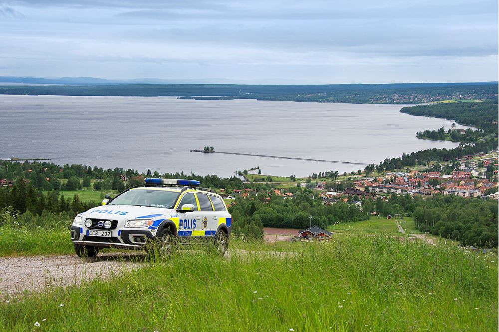 Polisbil på väg med Siljan i bakgrunden