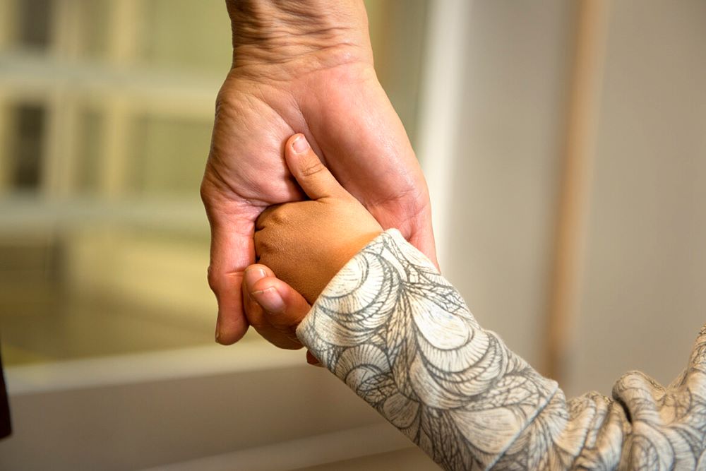 Bild på ett barns hand i en vuxens hand