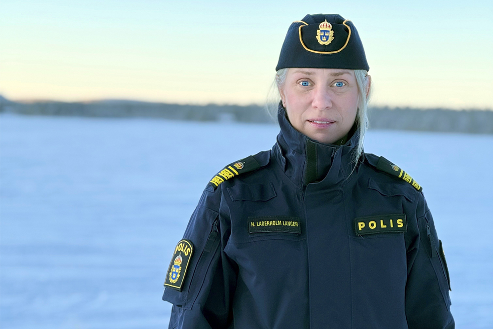 En kvinnlig polis tittar in i kameran. Snö i bakgrunden.