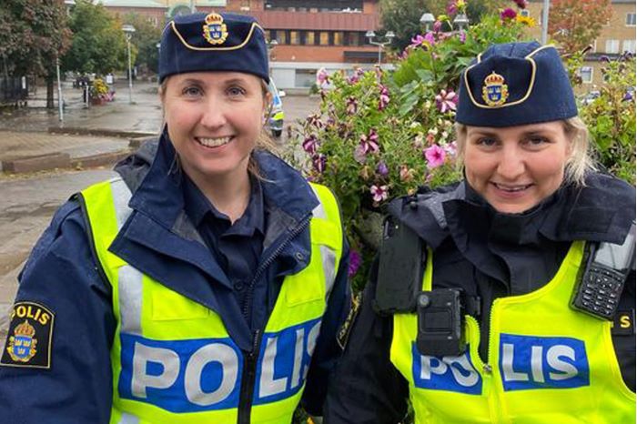 Två poliser som ler mot kameran.