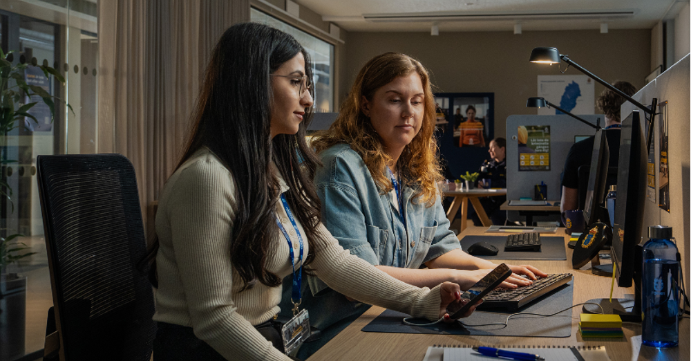 Två kvinnor sitter vid dataskärm