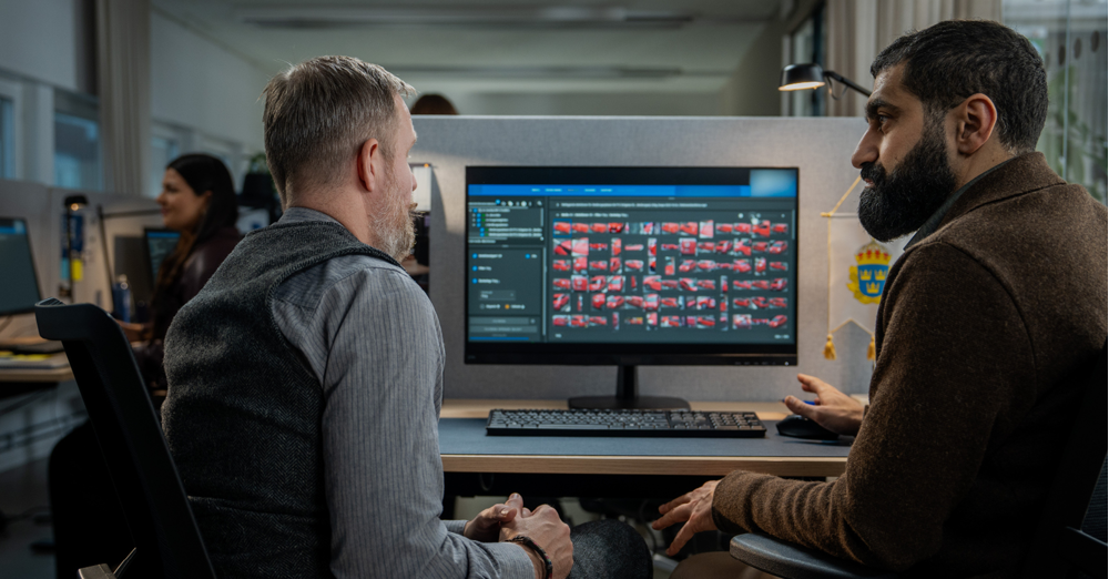 Två män sitter vid dataskärm