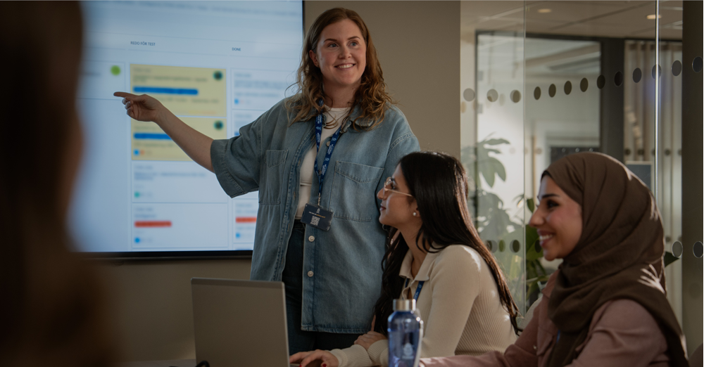 Kvinna pekar och visar på skärm på väggen