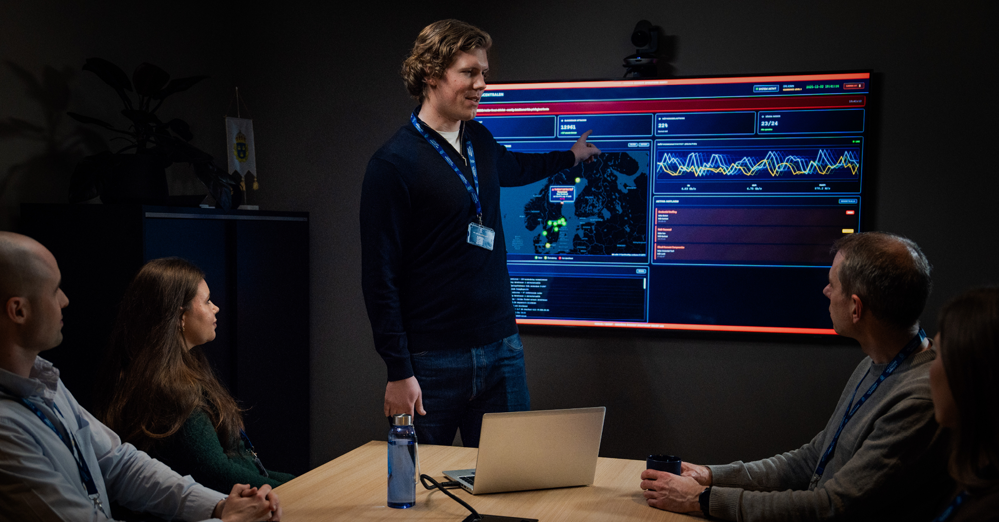 En man visar något på skärm på väggen