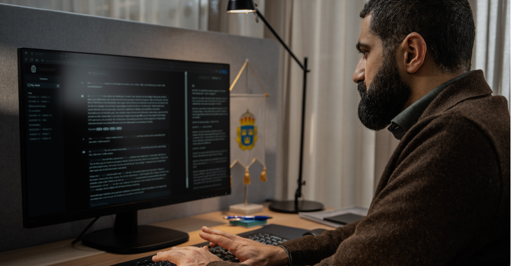 Man sitter framför dataskärm