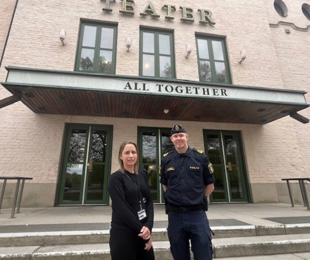 En civil kvinna står bredvid en manlig polis framför Eskilstuna teaters ingång.